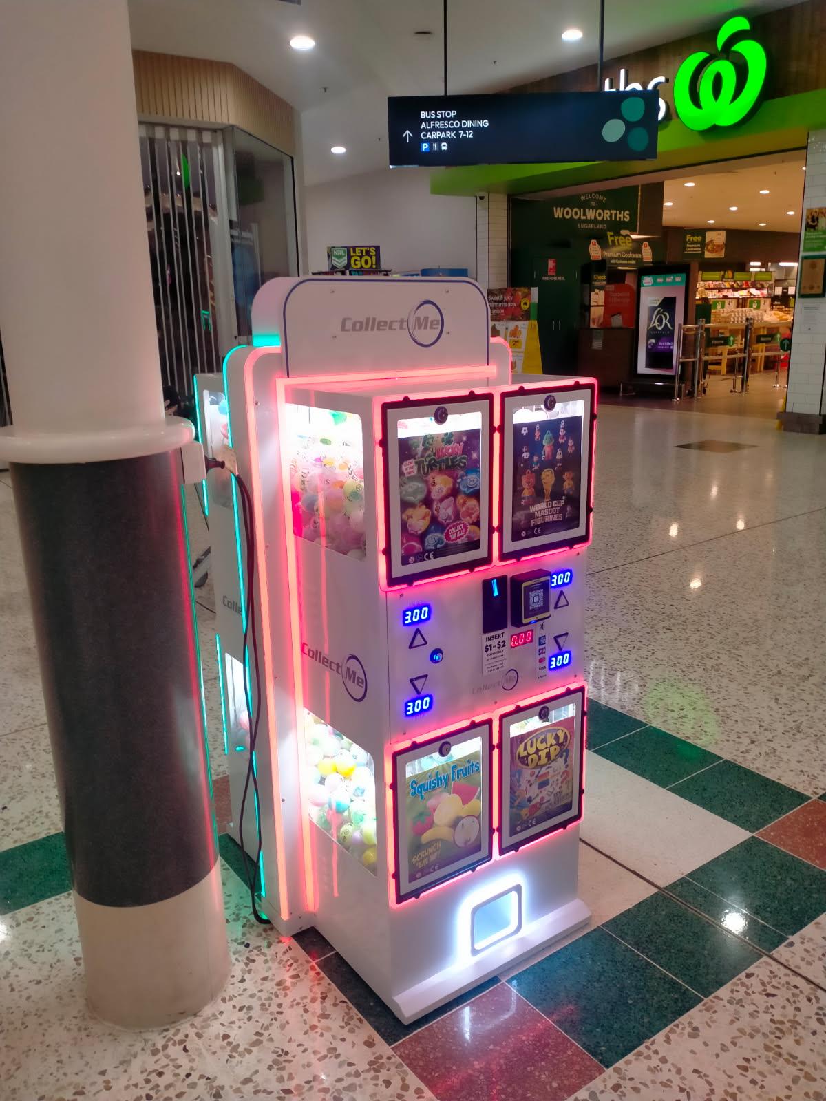 TVM capsule vending machine installed near a Woolworths supermarket entrance in a shopping centre